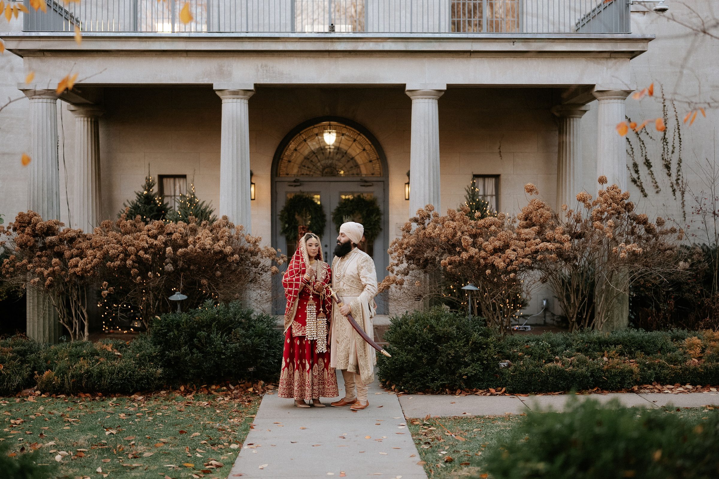 A Vaaho couple at the entrance of a historic manor in autumn
